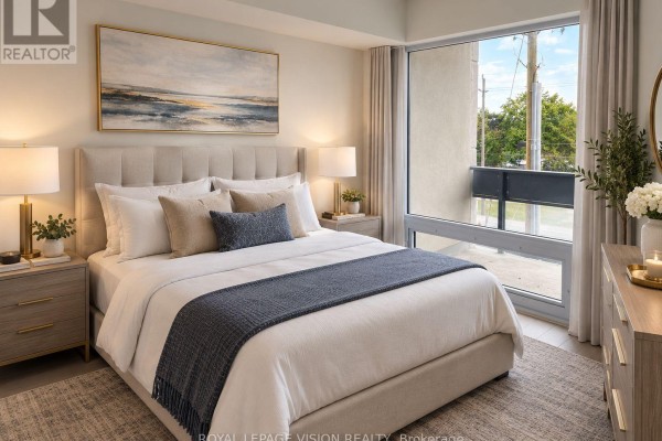 Primary bedroom with a king-size bed, nightstands, dresser, and a large window overlooking a balcony. - 329 - 4010 Eglinton Avenue W, Toronto
