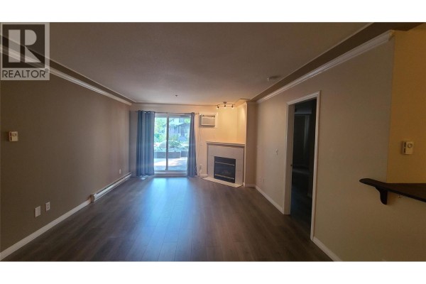 Covered concrete patio with a view of a street and surrounding houses. - 329 Rigsby Street Unit# 102, Penticton