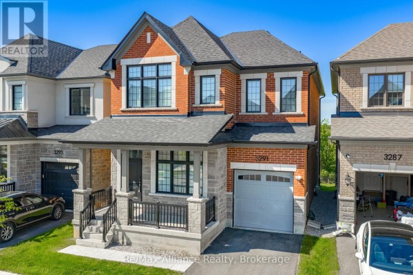 Front exterior of a two-story townhouse with red brick and stone accents. - 3291 Harasym Trail, Oakville