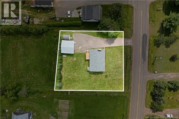 Aerial view of a property lot with a house, garage, and garden beds. - 3292 Route 132, Scoudouc