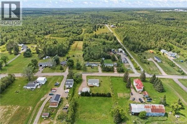 Aerial view of a small community with houses, roads, and surrounding farmland. - 3292 Route 132, Scoudouc