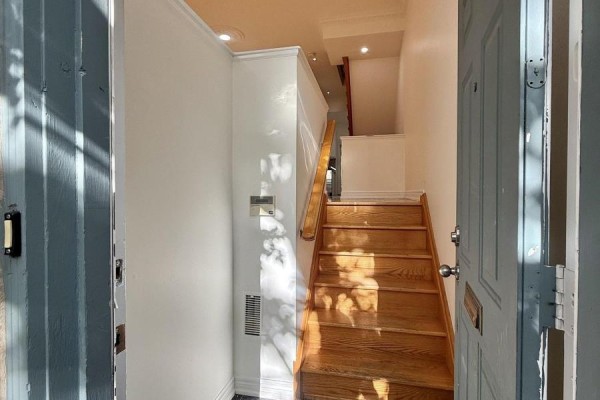 Kitchen with white cabinets, stainless steel appliances, and a gray quartz island. - 32d Oxford Street, Toronto