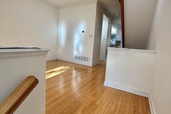 Modern kitchen with stainless steel appliances, white cabinets, and a turquoise accent wall. - 32d Oxford Street, Toronto