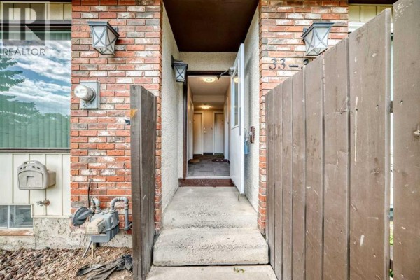 View of the townhouse entrance leading to an indoor hallway. - 33, 175 Manora Place, Calgary