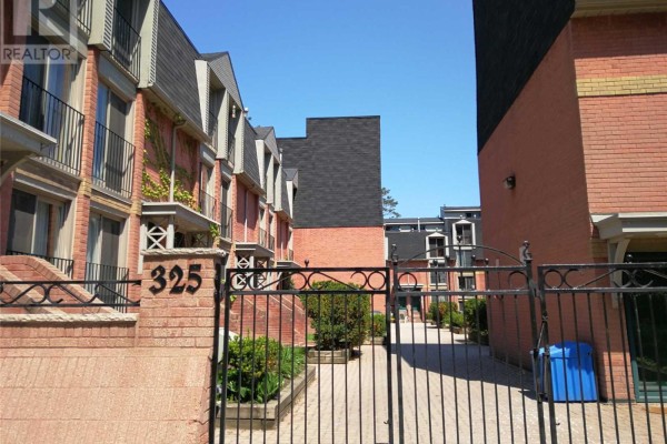 Gated courtyard entrance to townhouses at 325 Jarvis Street, Toronto, with brick buildings. - 33 - 325 Jarvis Street, Toronto