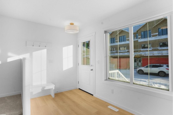 Spacious living room with large window and modern light fixture - #33 1009 Cy Becker Rd Nw, Edmonton