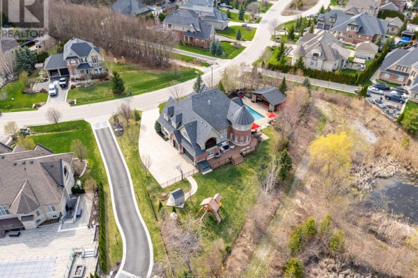 Aerial view of a large brick house's backyard featuring a pool, covered patio and deck. - 33 Barraclough Boulevard, Halton Hills