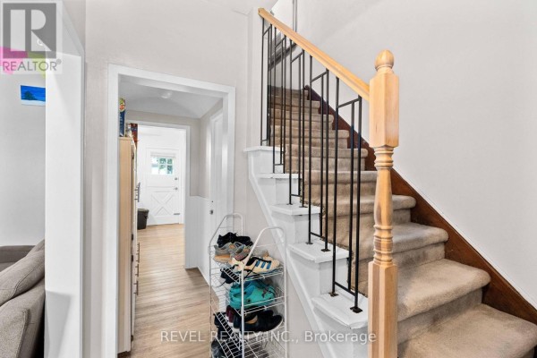 Bedroom with a bed, desk, plants, and closet, featuring natural light and wooden flooring. - 33 Cline Avenue N, Hamilton
