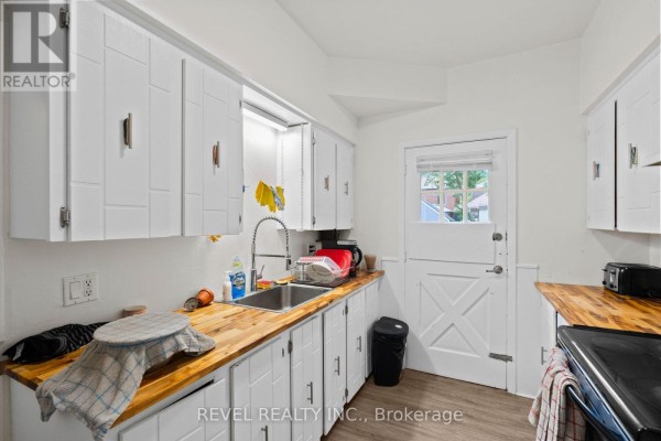 Bright bedroom with a bed, desk, and shelving, featuring a blue and white color scheme. - 33 Cline Avenue N, Hamilton