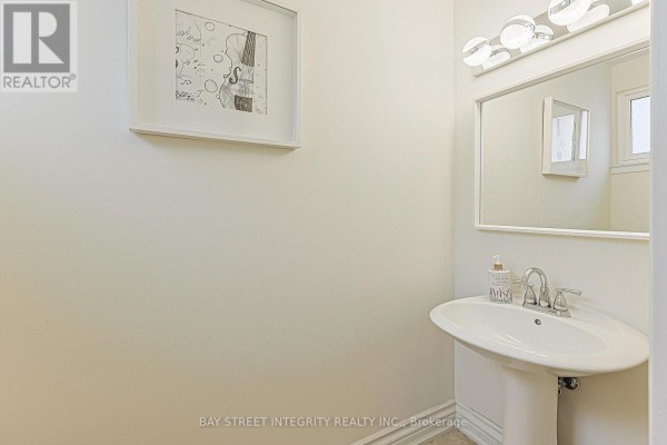 Pedestal sink, mirror, and modern light fixture in bathroom - 33 Deerford Road Toronto