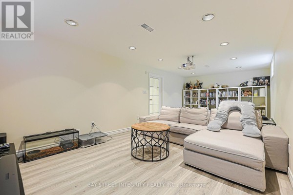 Basement living room with sectional sofa, projector, bookshelves, aquarium - 33 Deerford Road Toronto