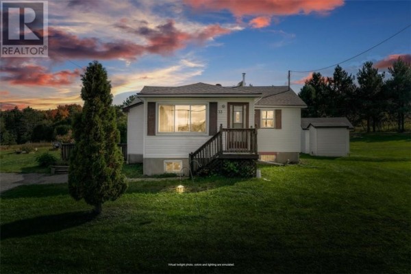 White vinyl-sided bungalow at dusk with illuminated windows and the sky displaying colorful sunset hues. - 33 Graham Road, Whitefish