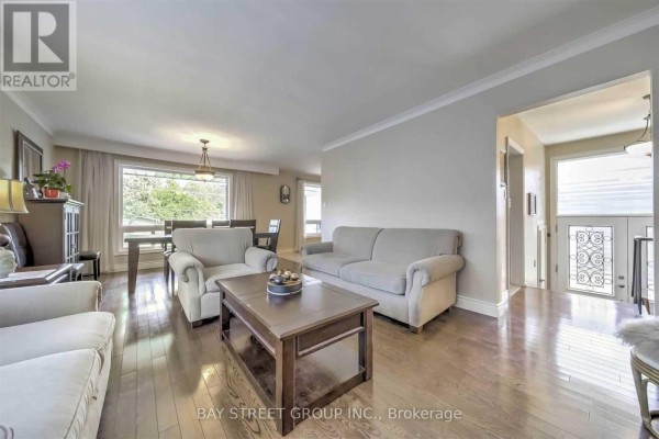 Living and dining room area with hardwood floors, neutral-colored furniture, and large windows. - 33 Heathview Avenue, Toronto