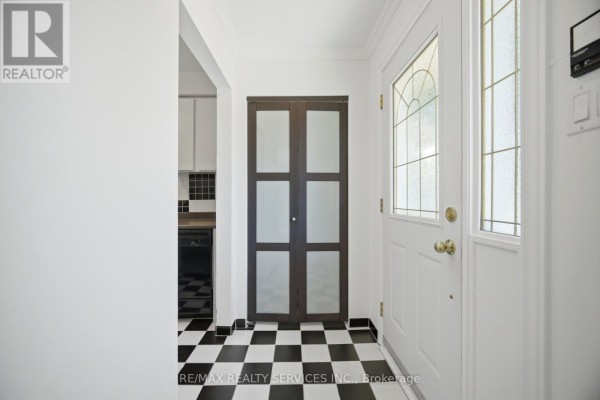 Interior foyer with checkered tile floors, a white door, and double frosted glass doors. - 33 Hesp Drive, Caledon