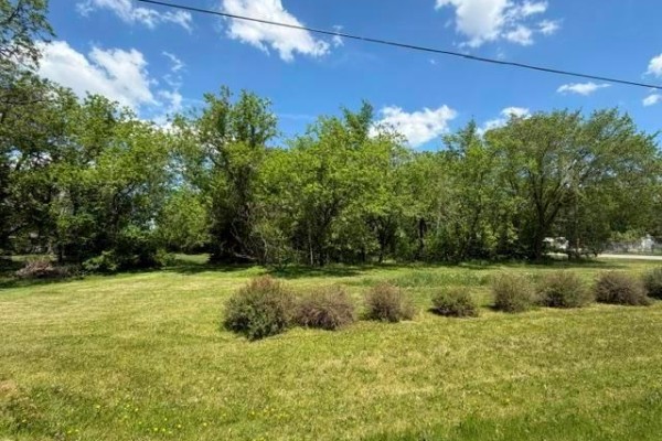 Aerial view of the property at 33 Main Street, Tyndall, outlined in red, surrounded by trees. - 33 Main Street, Tyndall