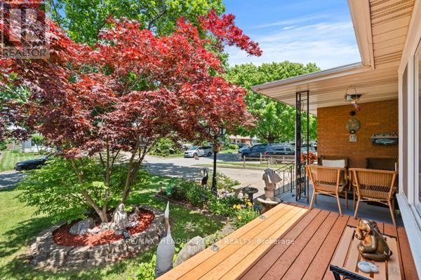 View from the covered porch looking out to the street and surrounding trees. - 33 Meadowbrook Crescent, St  Catharines