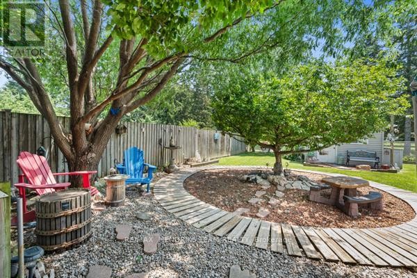 Yard with Adirondack chairs, picnic table, stone pathway, and trees - 33 Meadowbrook Crescent St  Catharines
