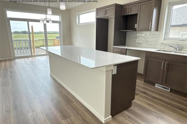 Kitchen island with white quartz countertop and dark brown base facing the dining area. - 33 Parkrose Place, St Adolphe