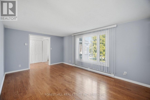 Living room with light blue walls, hardwood floors, and a large window with vertical blinds. - 33 Rice Drive, King