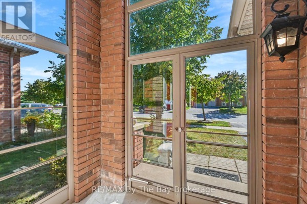 View through glass double doors of brick exterior and front walkway. - 33 Telfer Road, Collingwood