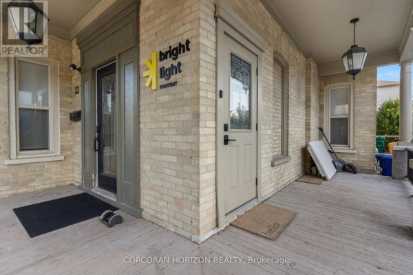Entrance area with two doors, one with "bright light" signage, on a wooden porch. - 33 Young Street, Waterloo
