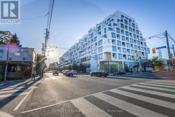 Exterior view of a modern, multi-story white apartment building on a sunny day. - 330 - 280 Howland Avenue, Toronto