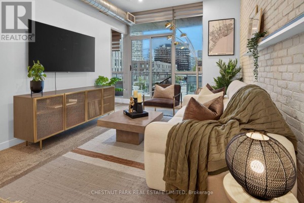 Living room view towards balcony doors showing city skyline at dusk. - 330 - 510 King Street E, Toronto