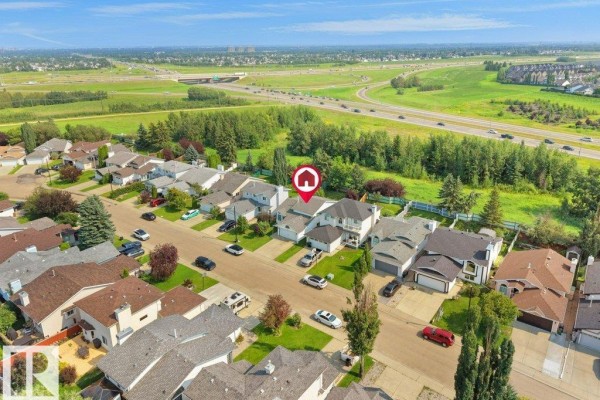 Aerial view of a suburban neighborhood with single-family homes and a highway in the background. - 330 Pearson Cr Nw, Edmonton