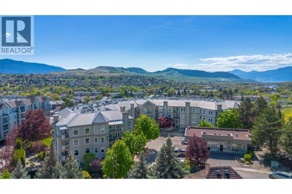Aerial view of the Regency Court apartment building surrounded by trees and mountains. - 3300 Centennial Drive Unit# 204, Vernon