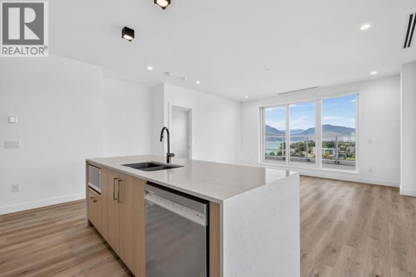 Living area and kitchen with island, dishwasher, and panoramic lake and city views. - 3300 Lakeshore Road Unit# 1303, Kelowna