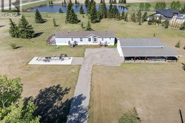 Open concept living, dining, and kitchen area with fireplace and large windows. - 33006 Range Road 290, Rural Mountain View County