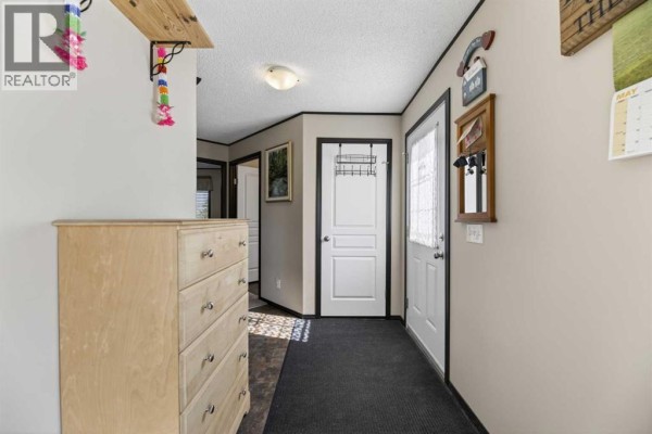 Second bathroom with a bathtub, shower curtain, toilet, and vanity with a large mirror. - 33006 Range Road 290, Rural Mountain View County