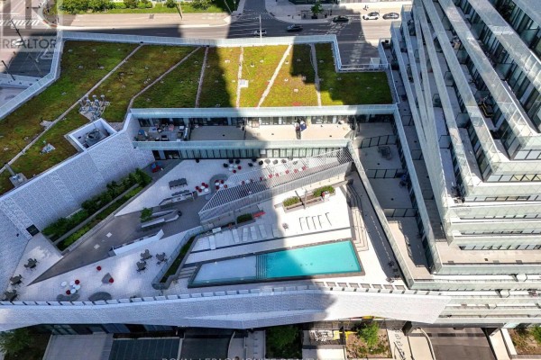 Spacious balcony with a seating area, dining table, and a view of the city skyline. - 3301 - 3900 Confederation Parkway, Mississauga