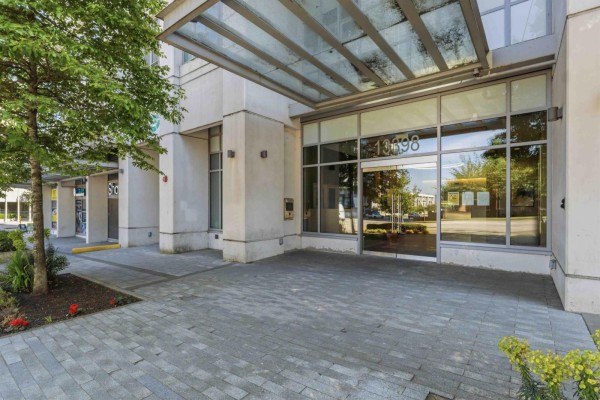 Exterior view of the apartment building entrance with glass doors and canopy. - 3301 13398 104 Avenue, Surrey