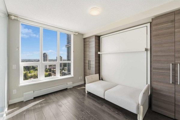 Bedroom with a murphy bed folded down, large window, and wood laminate flooring. - 3301 13398 104 Avenue, Surrey