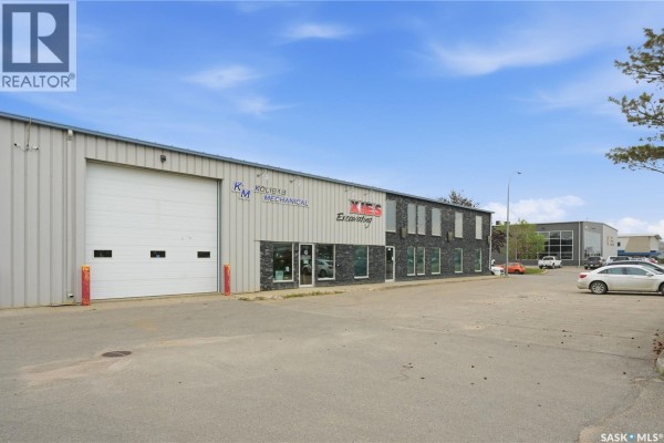 An angled exterior shot of the commercial building and adjacent properties, with a parking lot in the foreground. - 3302 Faithfull Avenue, Saskatoon