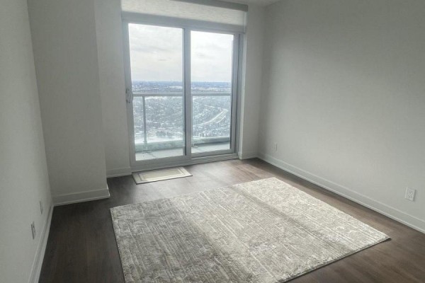 Bedroom with a large area rug and a sliding glass door leading to a balcony. - 3303 - 30 Upper Mall Way, Vaughan