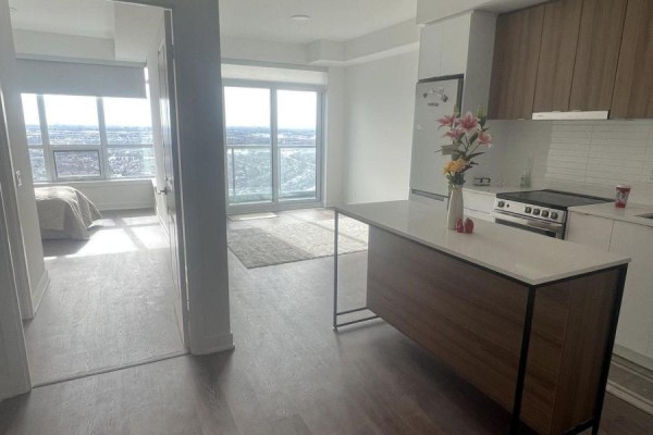Open concept living space with kitchen island, view of bedroom and balcony. - 3303 - 30 Upper Mall Way, Vaughan