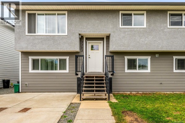 View down the stairs into the entryway with a white front door and gray walls. - 3303 Seventh St, Cumberland