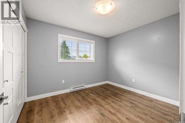 Kitchen with white cabinets, white appliances including a stove and refrigerator, and a large window over the sink. - 3303 Seventh St, Cumberland