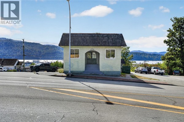 Small, light green building with a shingled roof and three windows, facing a body of water. - 3304 3rd Ave, Port Alberni