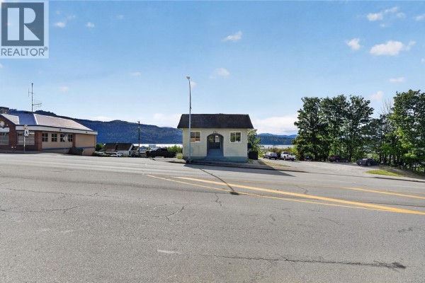 View of a small, light green building with a shingled roof and a water view. - 3304 3rd Ave, Port Alberni