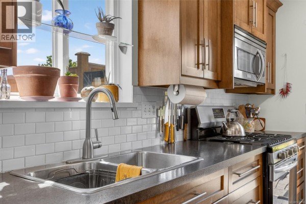 Kitchen sink with stainless steel double basin, chrome faucet, and granite countertops. White subway tile backsplash. - 3305 Ninth St, Cumberland