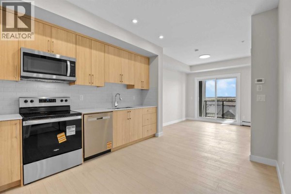 Open concept living space with a modern kitchen and a view of the balcony. - 3306, 100 Banister Drive, Okotoks