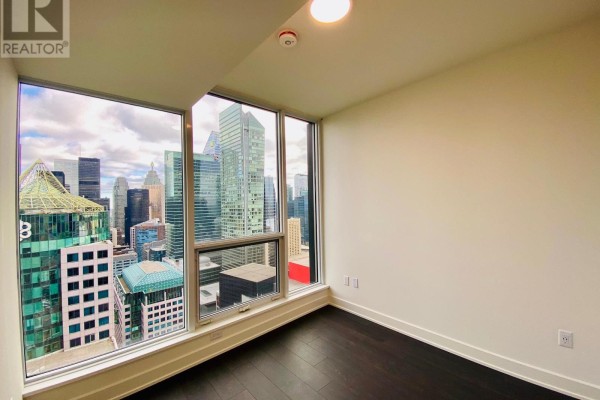 Empty bedroom with large windows offering panoramic city views. - 3306 - 15 Mercer Street, Toronto