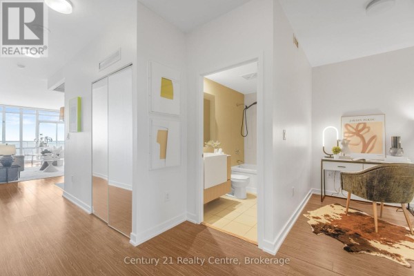 Hallway with closet, bathroom, and a desk area with a chair and artwork. - 3307 - 21 Iceboat Terrace, Toronto
