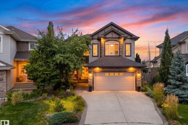 Front exterior of a two-story home with a garage, stone accents, and landscaping at dusk. - 331 Callaghan Cl Sw, Edmonton