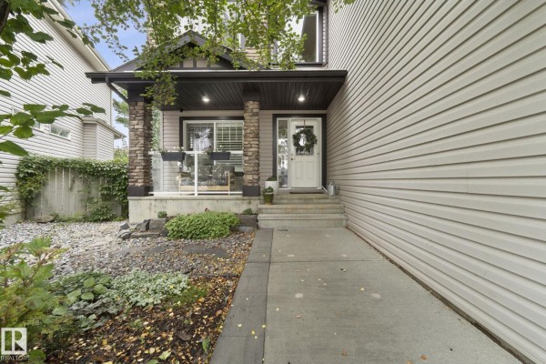 Covered front porch with stone pillars, a glass door, and a sidewalk leading to the entrance. - 331 Callaghan Cl Sw, Edmonton