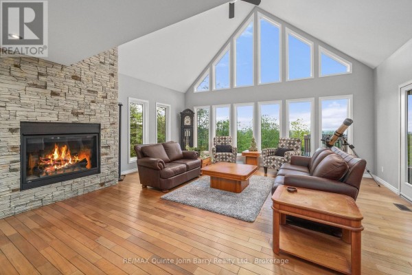Comfortable family room with grey sofas, a glass coffee table, and a large television. - 331 Drewery Street, Brighton