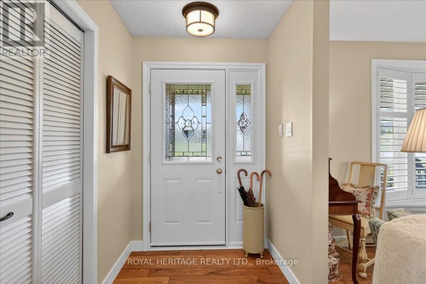 Kitchen with light wood cabinets, stainless steel appliances, white subway tile backsplash, and hardwood floors. - 331 Port Colony Road, Kawartha Lakes